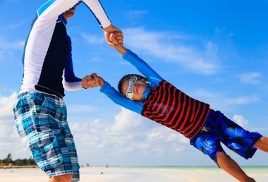 Baba ve oğul sahilde oynuyorlar.