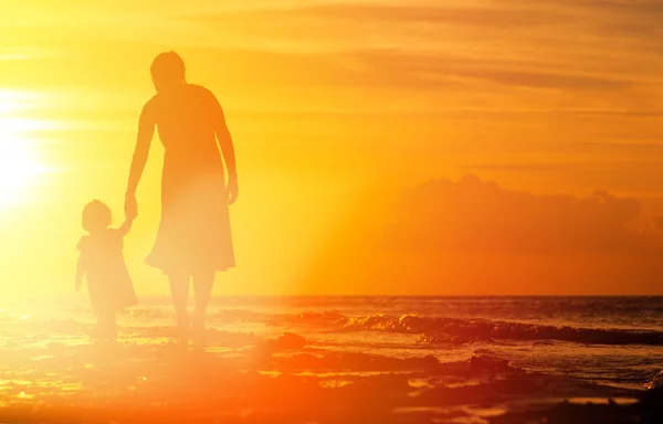 Mère et petite fille marchant au coucher du soleil — Photo