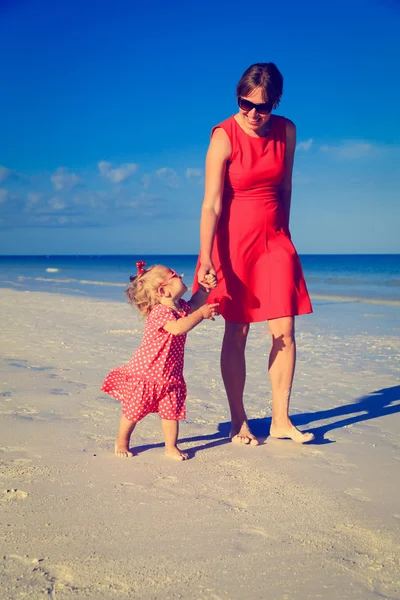 在沙滩上散步的小女儿和妈妈 — 图库照片