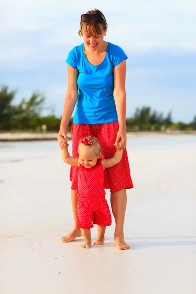 Mère et petite fille marchant sur la plage — Photo