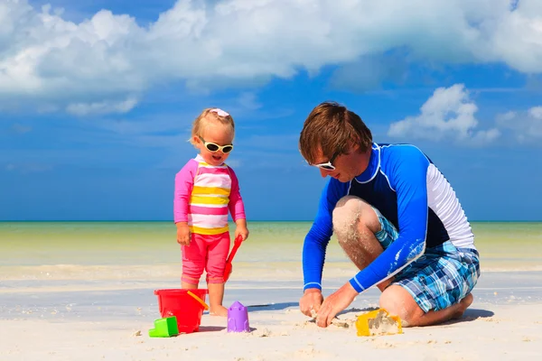 Tată și fiică mică jucându-se cu nisip pe plajă — Fotografie, imagine de stoc