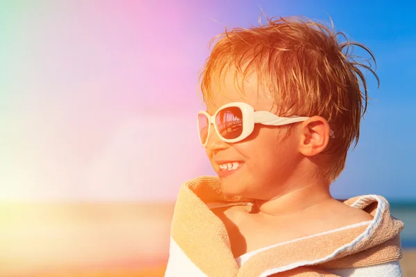 Feliz menino rir envolto em toalha de praia no céu — Fotografia de Stock