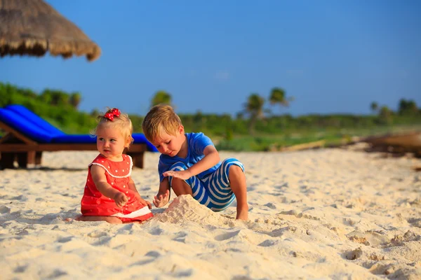 Crianças brincando com areia na praia de verão — Fotografia de Stock