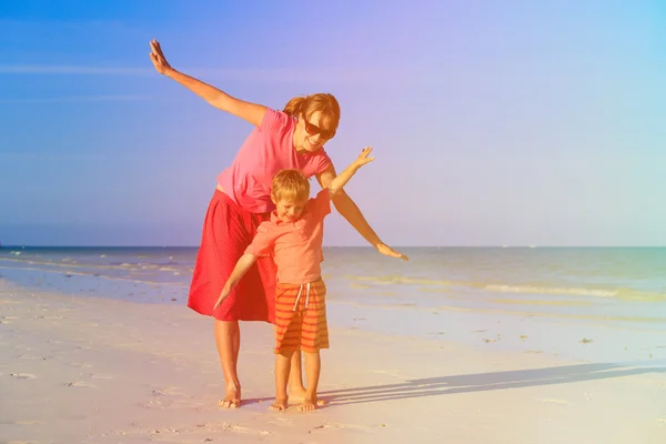 Mother and son flying on the beach — Stock Photo, Image