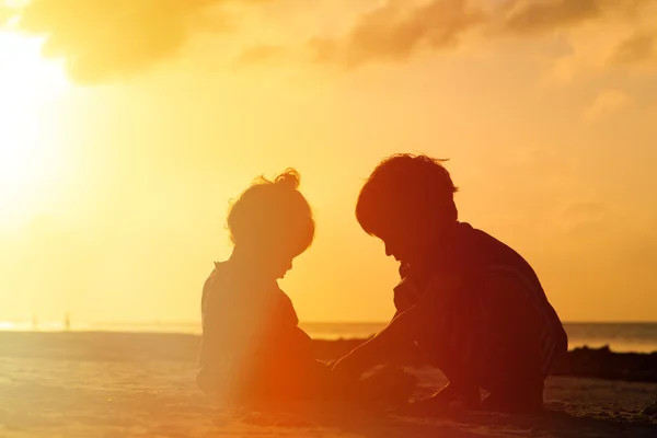 Menino e menina brincando ao pôr do sol — Fotografia de Stock