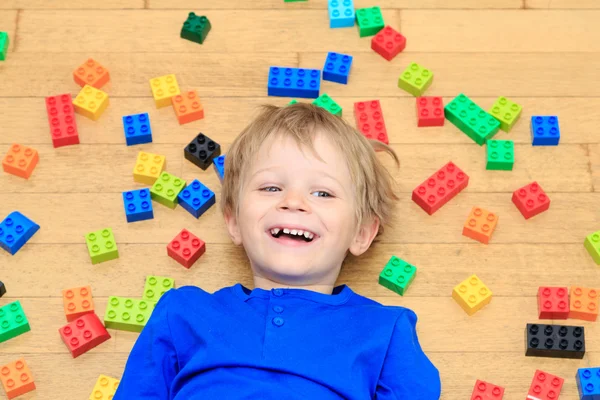 Niño jugando con bloques de plástico de colores en interiores —  Fotos de Stock