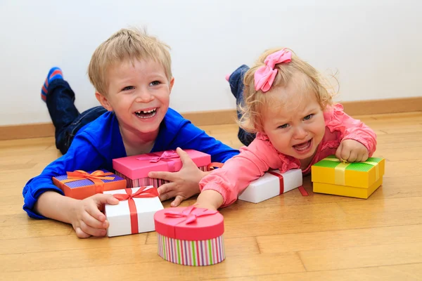 Brother and sister rivalry, sorting presents — Stock Photo, Image