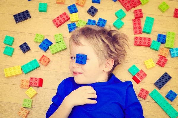 Dziecko bawiąc się kolorowe bloki plastikowe wnętrze — Zdjęcie stockowe