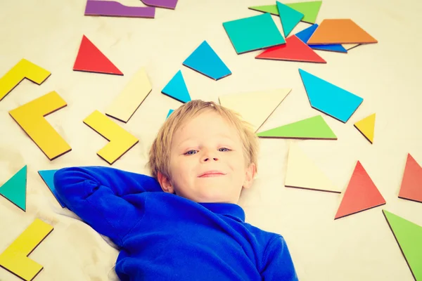 Happy little boy with puzzle toys on white — Stock Photo, Image
