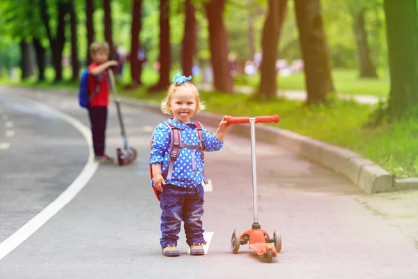 2 人の子供の男の子と女の子の街にスクーターに乗って — ストック写真