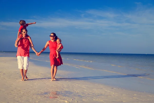 모래 해변에 산책 하는 두 아이 가진 가족 — 스톡 사진