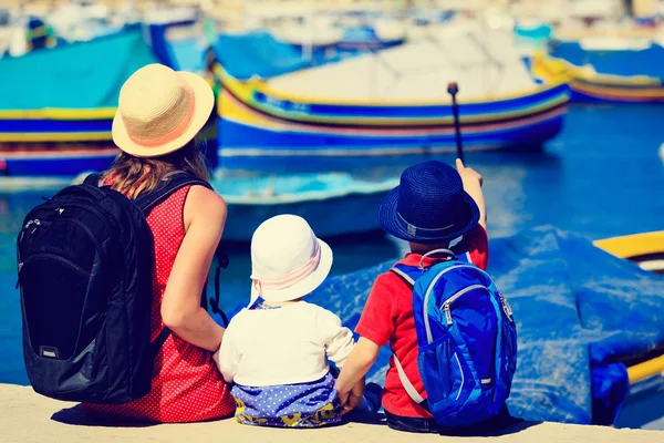Mãe e crianças olhando para barcos tradicionais em Malta — Fotografia de Stock