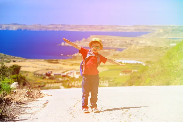 Маленький мальчик путешествует с рюкзаком на живописной дороге — стоковое фото