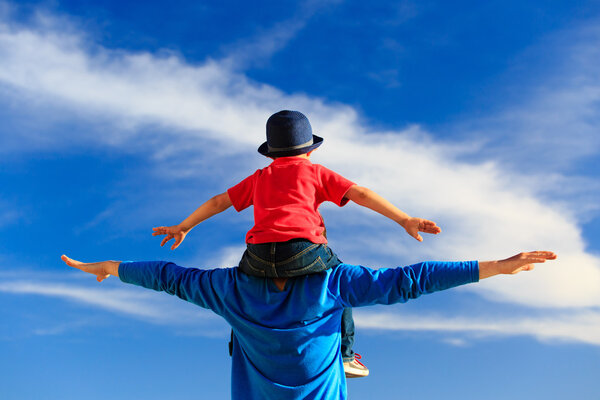 Отец и маленький сын играют на небе
