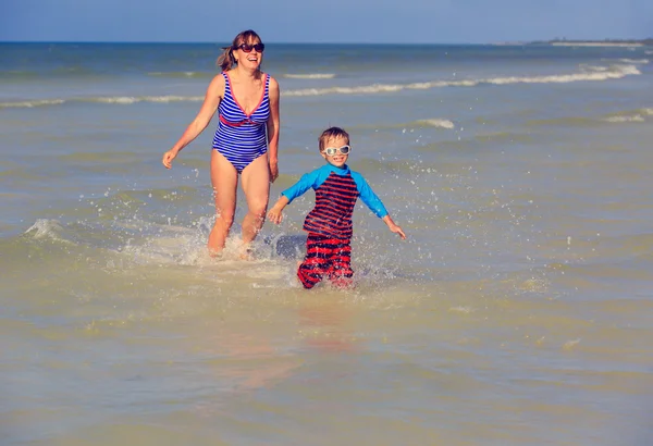 Mãe e filho correndo no mar — Fotografia de Stock