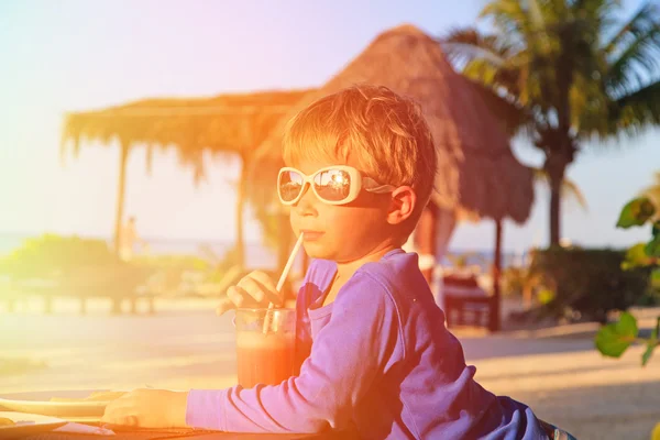 Menino bebendo suco na praia tropical — Fotografia de Stock