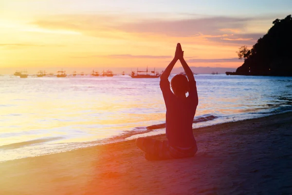 Silueta de hombre joven haciendo yoga al atardecer — Foto de Stock