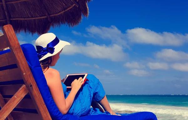Frau mit Touchpad am tropischen Strand — Stockfoto