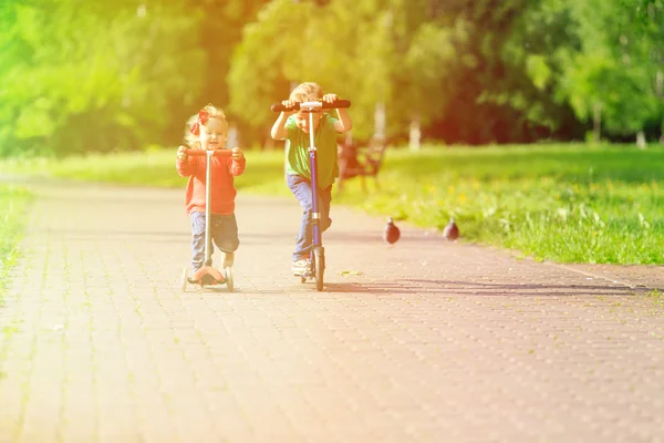 Kinder fahren Roller im Sommerpark — Stockfoto