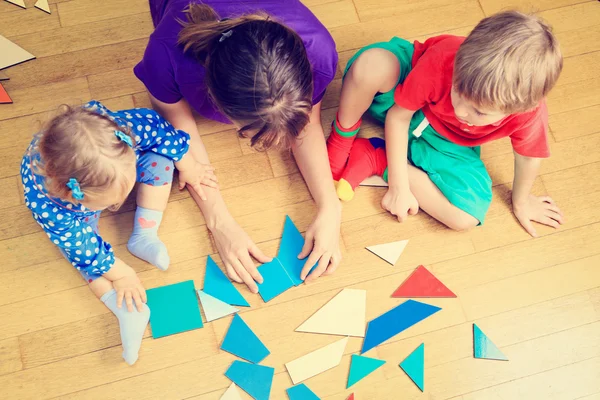 Teacher and kids playing with geometric shapes — Stock Photo, Image