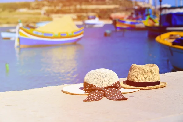 Две шляпы с традиционными мальтийскими лодками на заднем плане — стоковое фото