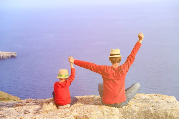 Feliz pai e filho sentados no topo de uma montanha — Fotografia de Stock