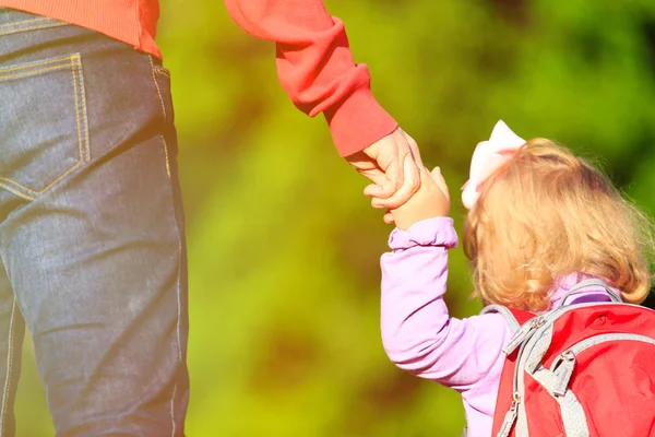 Madre cogida de la mano de la pequeña hija al aire libre — Foto de Stock