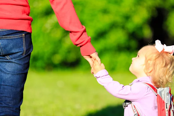 Madre cogida de la mano de la pequeña hija al aire libre — Foto de Stock