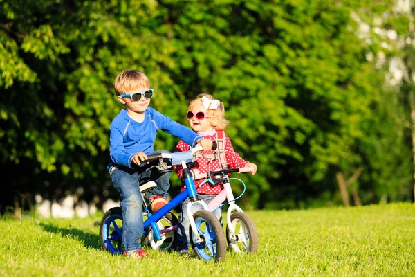 Menino e criança menina em bicicletas no parque de verão — Fotografia de Stock