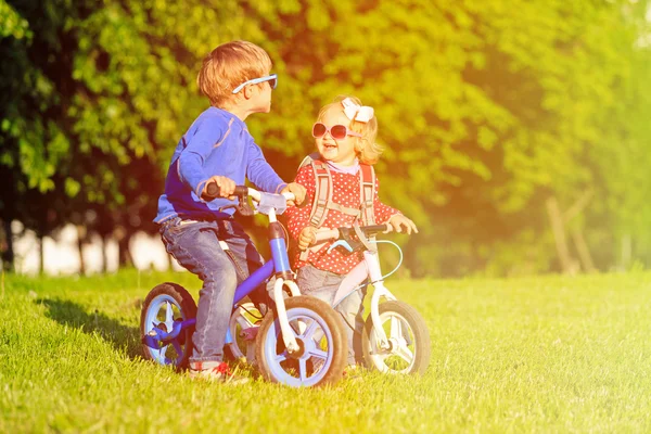 Anak laki-laki dan perempuan balita bersepeda di taman musim panas — Stok Foto