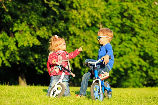 Little boy and toddler girl on bikes in summer park — Stock Photo, Image