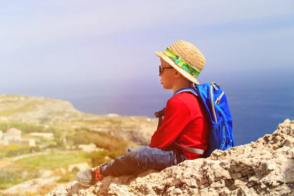 Маленький мальчик в походе в горах, глядя на живописный вид — стоковое фото