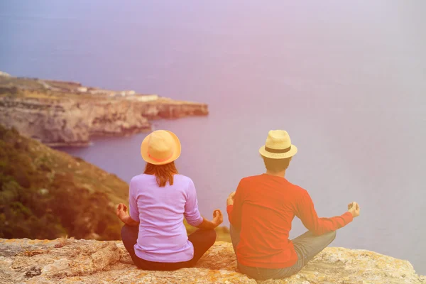 Par praktiserer yoga i naturskønne sommer bjerge - Stock-foto