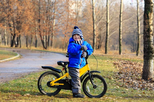 Glücklicher kleiner Junge mit Fahrrad im Herbstpark — Stockfoto