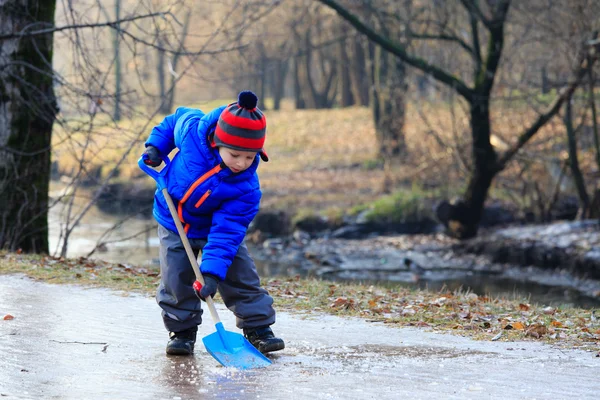 Niño pequeño limpiando hielo con pala — Foto de Stock