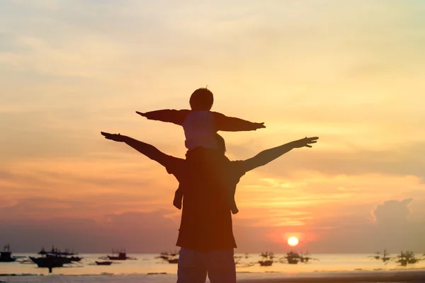 Père et fils s'amuser sur la plage du coucher du soleil — Photo