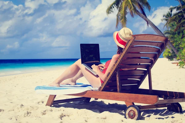 Frau mit Laptop im Strandurlaub — Stockfoto
