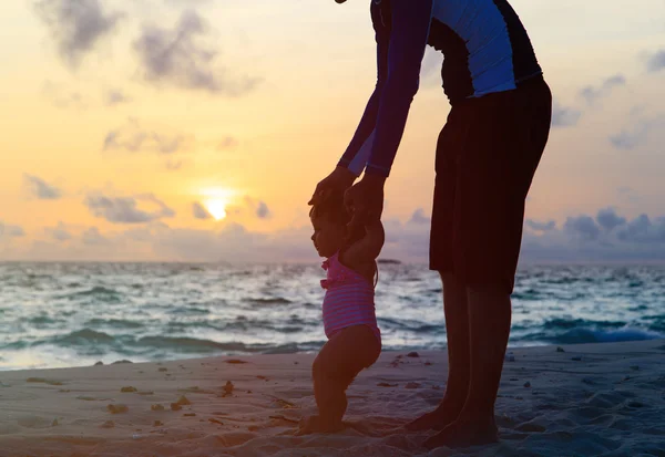 Père et petite fille marchant sur la plage du coucher du soleil — Photo