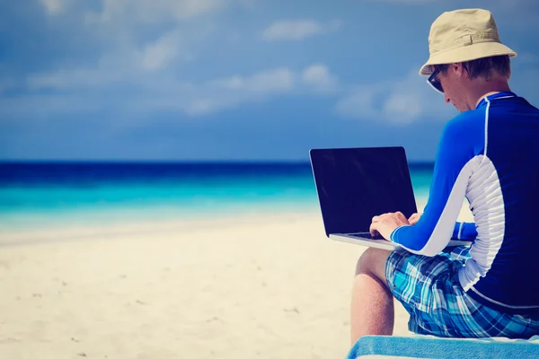 Hombre con el ordenador portátil en vacaciones de playa Fotos De Stock Sin Royalties Gratis