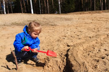 küçük çocuk baharda kum kazma