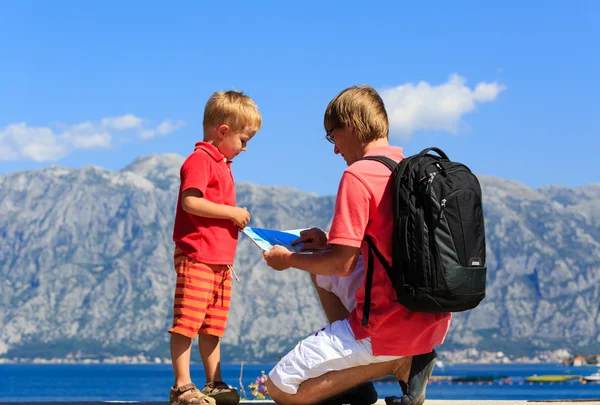 Far och son titta på karta på semester — Stockfoto