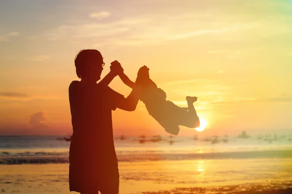 Silhouettes père et fils jouent au coucher du soleil — Photo