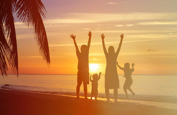 Famille heureuse avec deux enfants s'amusant au coucher du soleil — Photo