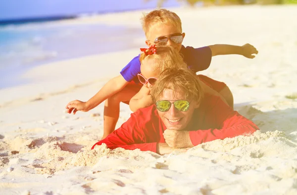Padre felice con due bambini che si divertono sulla spiaggia di sabbia — Foto Stock