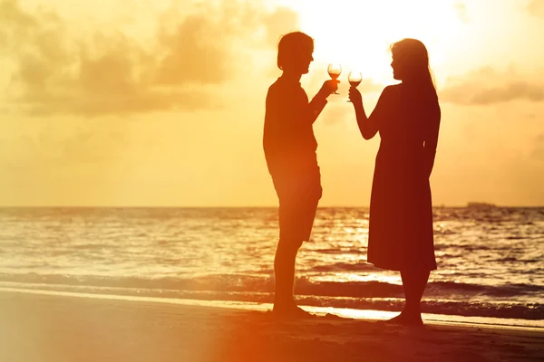 Silhouet van koppel dat wijn drinkt bij zonsondergang — Stockfoto