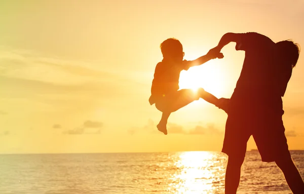 Vader en zoontje spelen bij zonsondergang — Stockfoto