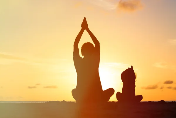 Father and little daughter doing yoga at sunset — Stock Photo, Image