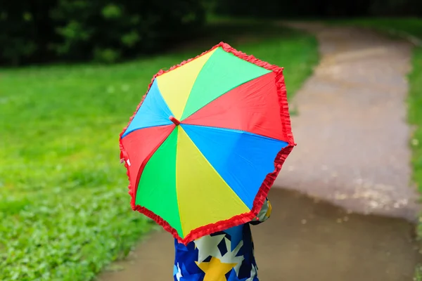 Anak kecil yang bersembunyi di balik payung berwarna-warni di luar — Stok Foto