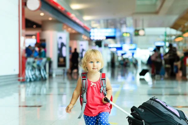 Liten flicka med resväska resor på flygplatsen — Stockfoto