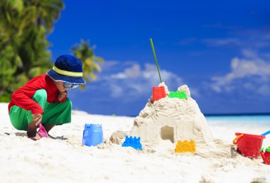 küçük çocuk bina Sandcastle tropik sahilde